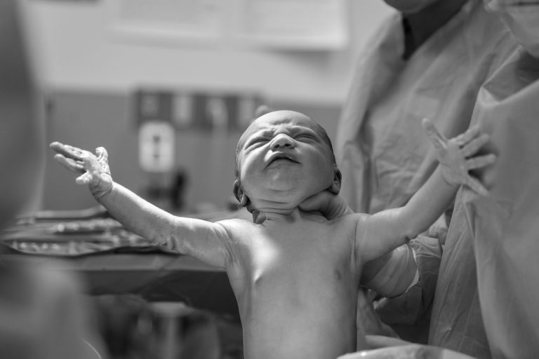bambino neonato con mano al collo del medico